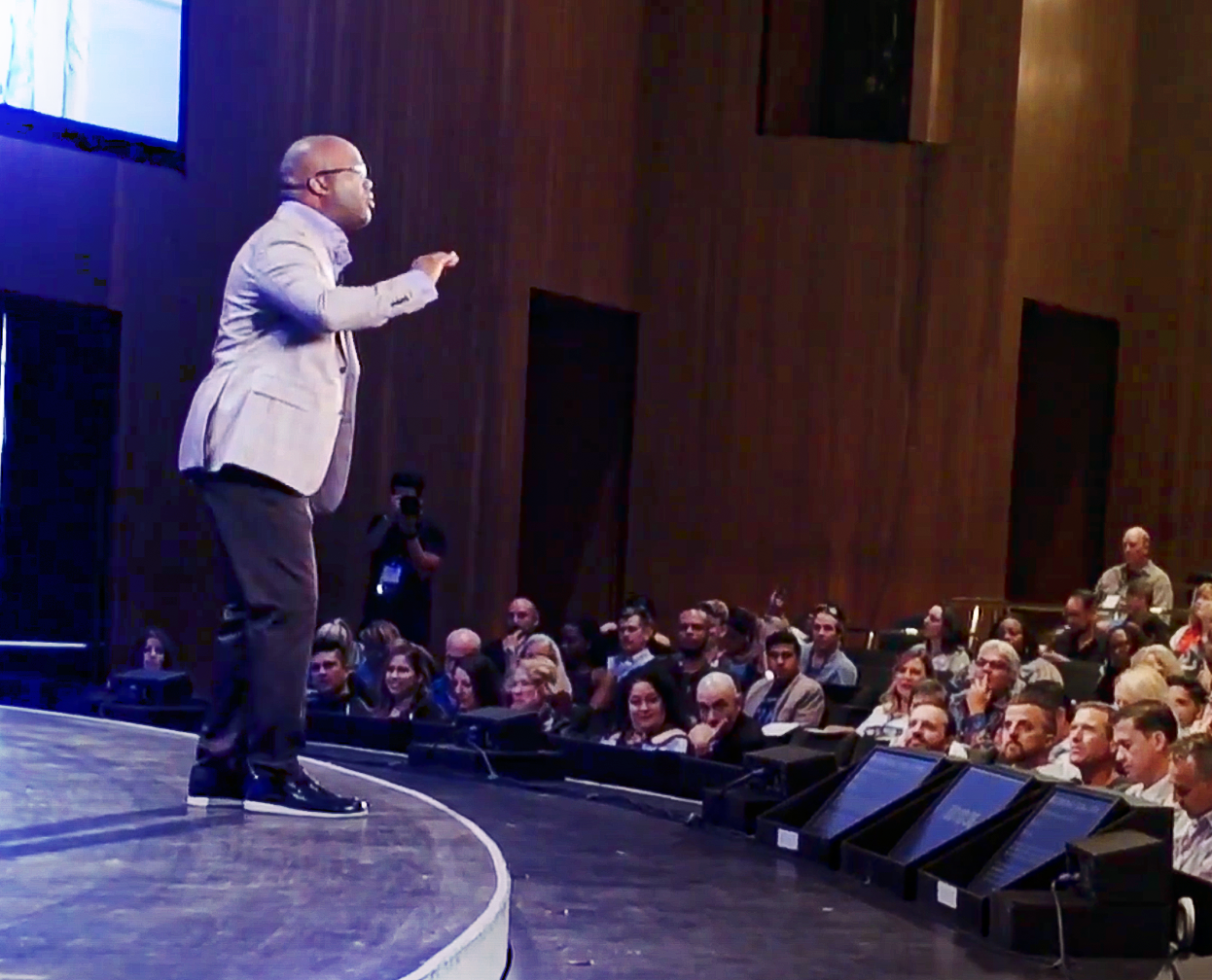 Simon T. Bailey speaking in front of a large audience